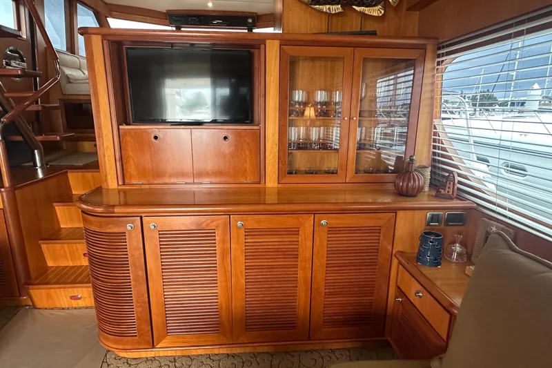 Slide: The Image of Luxurious yacht interior with wooden cabinetry, TV, and glassware display, Symbol 56, 2003 model. - 26