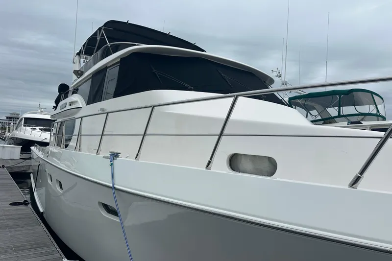 Slide: The Image of Luxury yacht Symbol 56, 2003 model, docked at marina under cloudy skies. - 5