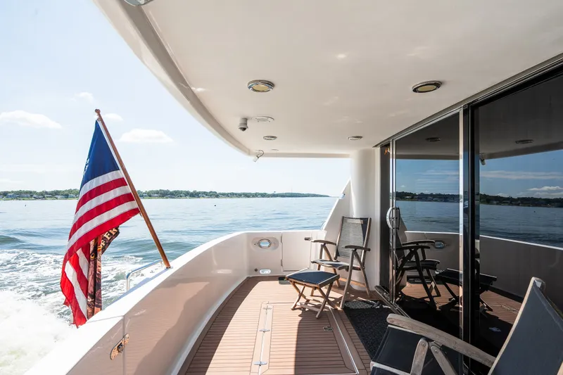 Slide: The Image of Luxury yacht deck with chairs, American flag, and ocean view, Symbol 56, 2003 model. - 15