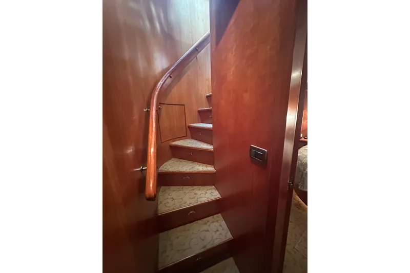 Slide: The Image of Curved wooden staircase inside a 2003 Symbol 56 yacht, featuring elegant carpeted steps. - 60