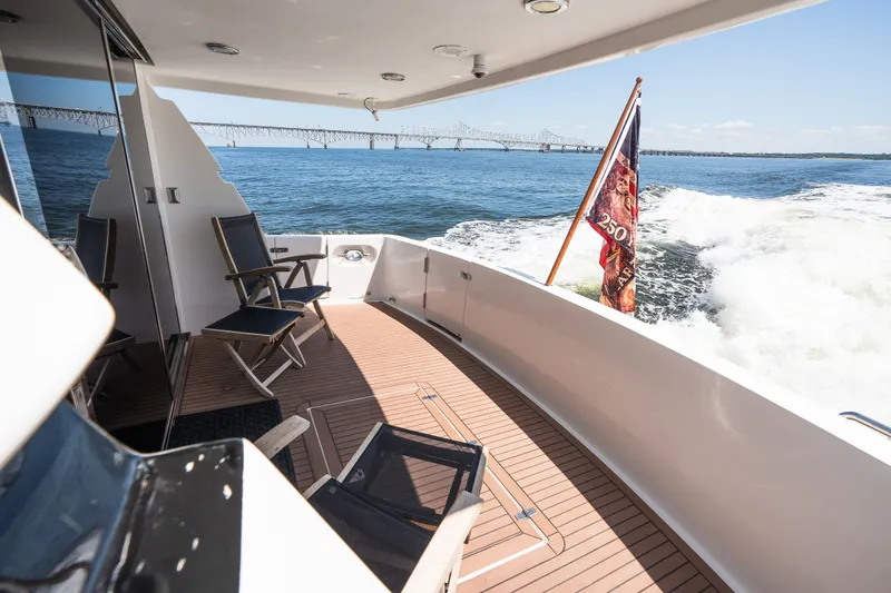 Slide: The Image of Luxury yacht deck with chairs, ocean view, and bridge in the background, Symbol 56, 2003 model. - 17