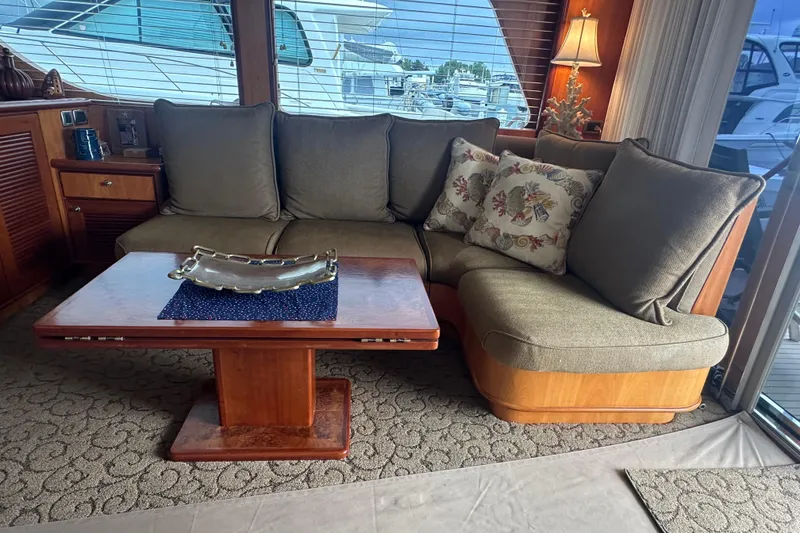 Slide: The Image of Luxurious yacht interior with a cozy L-shaped sofa, wooden table, and decorative pillows. - 24