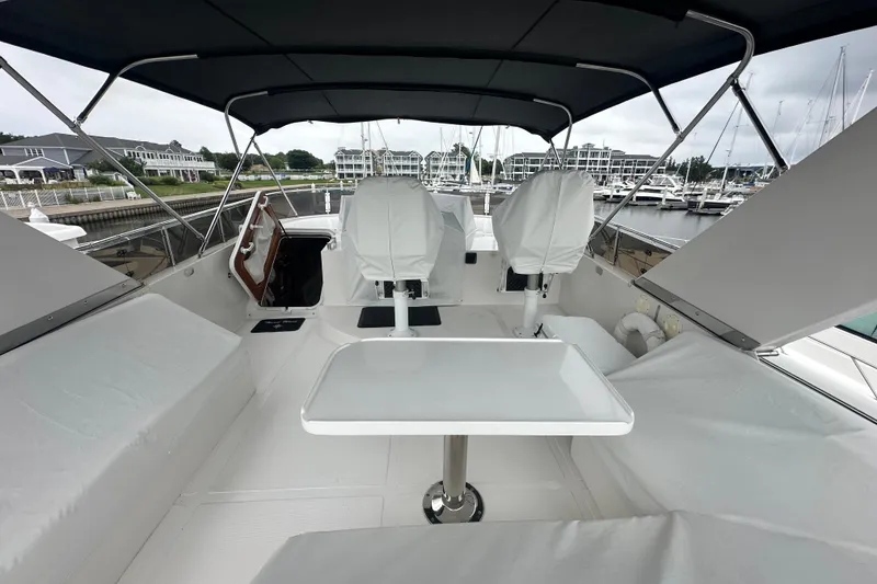 Slide: The Image of Luxury yacht deck with covered seating and table, Symbol 56 model, 2003, docked at marina. - 16