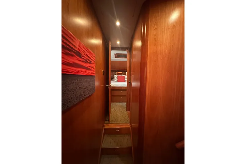 Slide: The Image of Narrow wooden hallway leading to a cozy bedroom in a 2003 Symbol 56 yacht. - 53