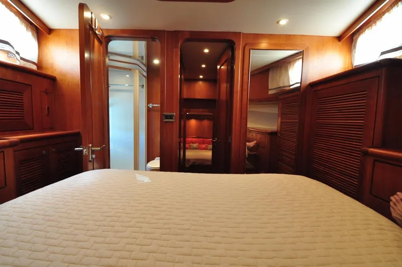 Slide: The Image of Luxurious wooden interior of a 2003 Symbol 56 yacht cabin with cozy bedding. - 29