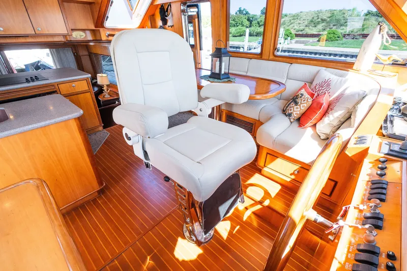 Slide: The Image of Luxurious yacht interior with plush seating, wooden accents, and helm station, Symbol 56 model, 2003. - 62