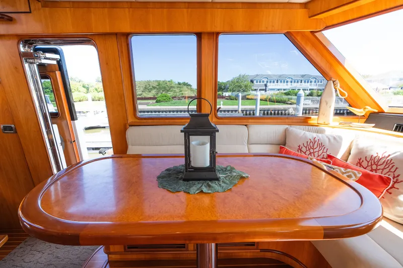 Slide: The Image of Luxurious yacht interior with wooden table, lantern centerpiece, and scenic window view. Symbol 56, 2003 model. - 59