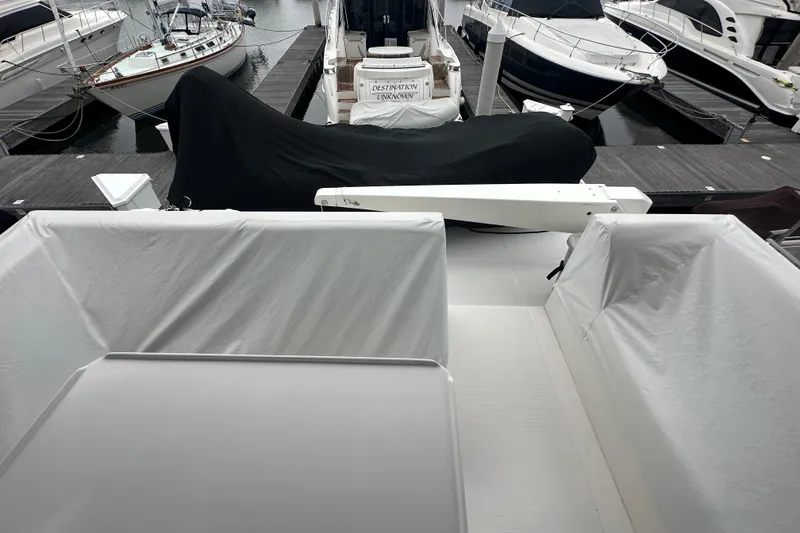 Slide: The Image of Covered boats docked at a marina, featuring a 2003 Symbol 56 model. - 13
