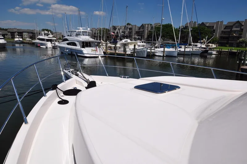 Slide: The Image of Bow view of a 2003 Symbol 56 yacht docked in a marina under a clear blue sky. - 4