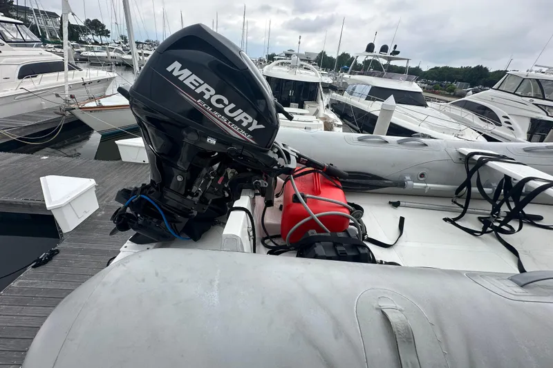 Slide: The Image of Inflatable boat with Mercury outboard motor docked at marina, surrounded by yachts. - 18