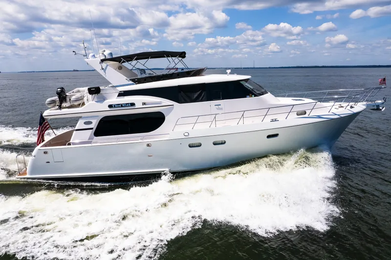 The Image of Luxurious 2003 Symbol 56 yacht cruising on open water under a partly cloudy sky. - 0