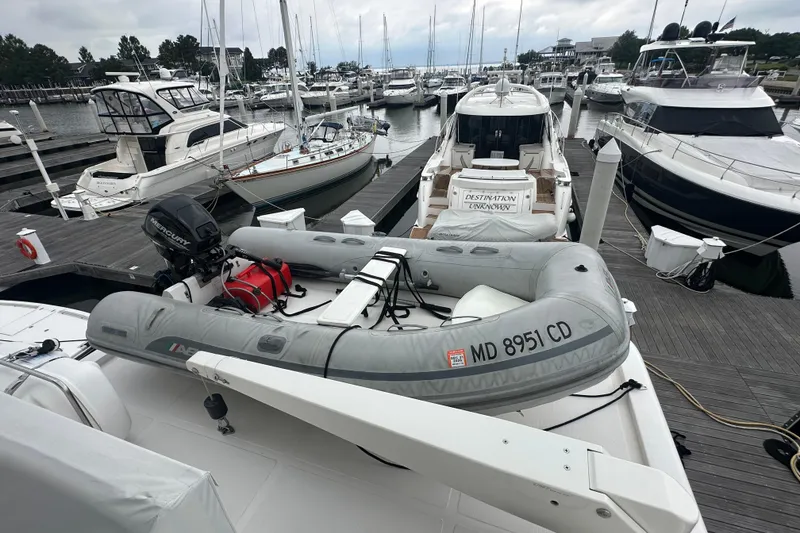 Slide: The Image of Inflatable boat with outboard motor docked among luxury yachts, Symbol 56, 2003 model. - 19