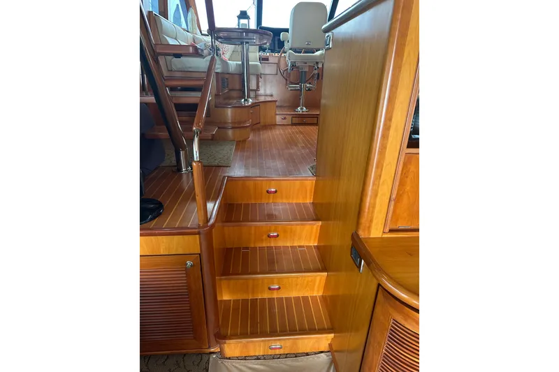 Slide: The Image of Wooden interior stairs on a 2003 Symbol 56 yacht, leading to the helm area. - 27