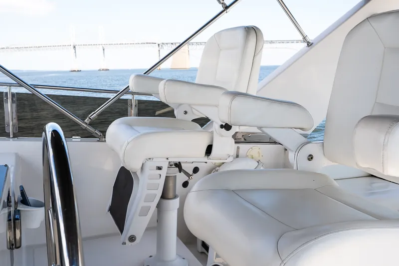 Slide: The Image of Luxury yacht helm with white leather seats, overlooking a scenic bridge and water view. - 35