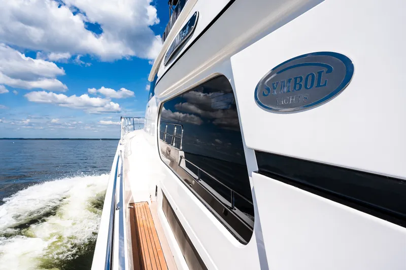 Slide: The Image of Luxury Symbol 56 yacht cruising on open water under a clear blue sky. - 18