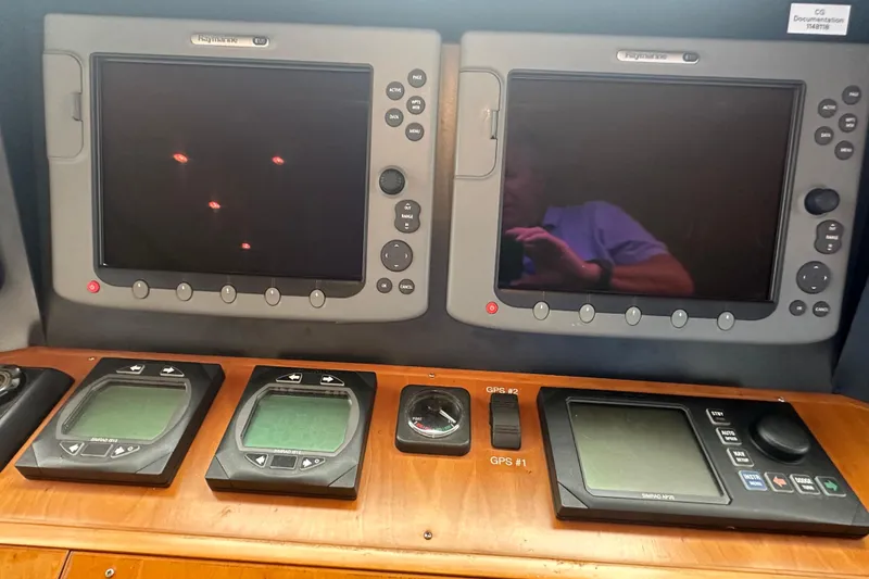 Slide: The Image of Control panel of a 2003 Symbol 56 yacht with navigation screens and GPS displays. - 41