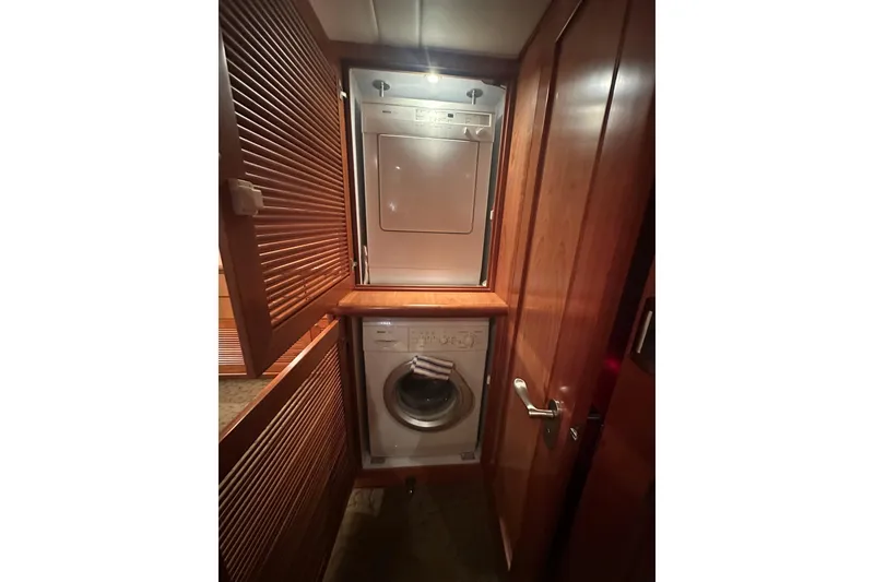 Slide: The Image of Compact laundry area with stacked washer and dryer in wooden cabinet, Symbol 56, 2003 model. - 48