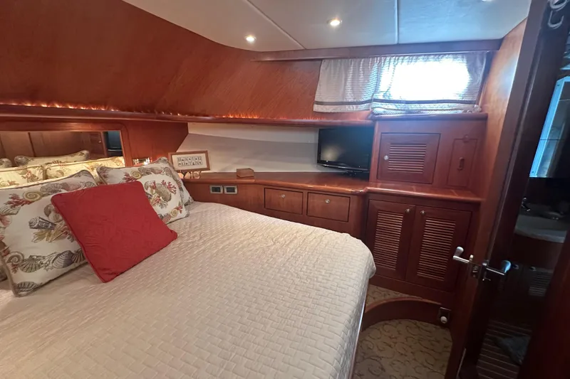 Slide: The Image of Luxurious yacht bedroom with wood paneling, cozy bedding, and a small TV, Symbol 56, 2003. - 55