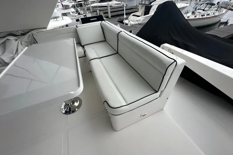 Slide: The Image of Luxurious seating area on a 2003 Symbol 56 yacht, featuring sleek white cushions and a modern table. - 14