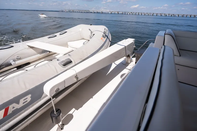 Slide: The Image of Luxury yacht deck with inflatable boat, ocean view, and distant bridge under a clear sky. - 44