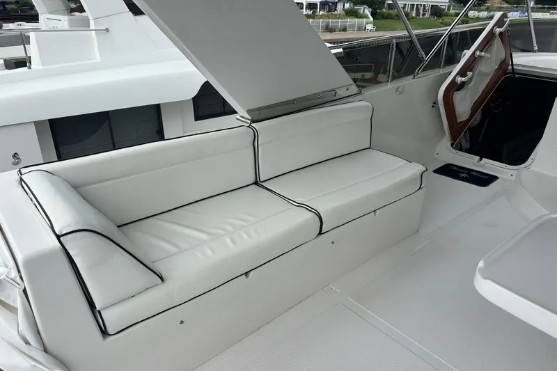 Slide: The Image of White cushioned seating on a 2003 Symbol 56 yacht deck, featuring sleek design and comfort. - 11