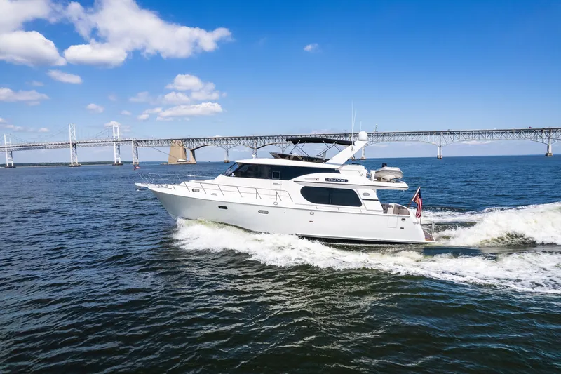 Slide: The Image of A 2003 Symbol 56 yacht cruising near a large bridge under a clear blue sky. - 12