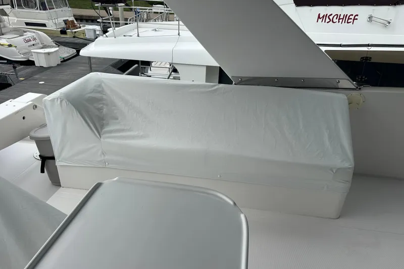 Slide: The Image of Covered seating area on a 2003 Symbol 56 yacht, docked near other boats. - 12