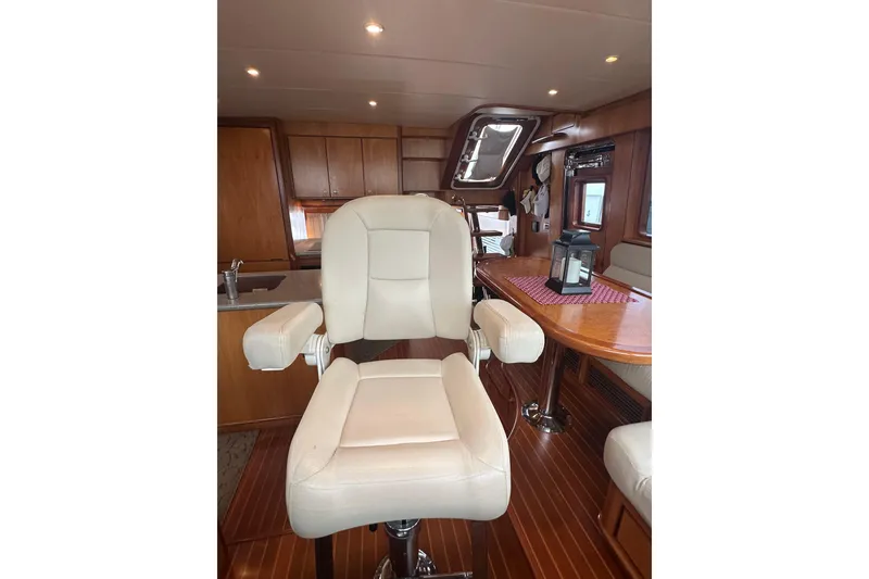 Slide: The Image of Luxurious yacht interior with a plush white captain's chair, wooden cabinetry, and dining area. - 37