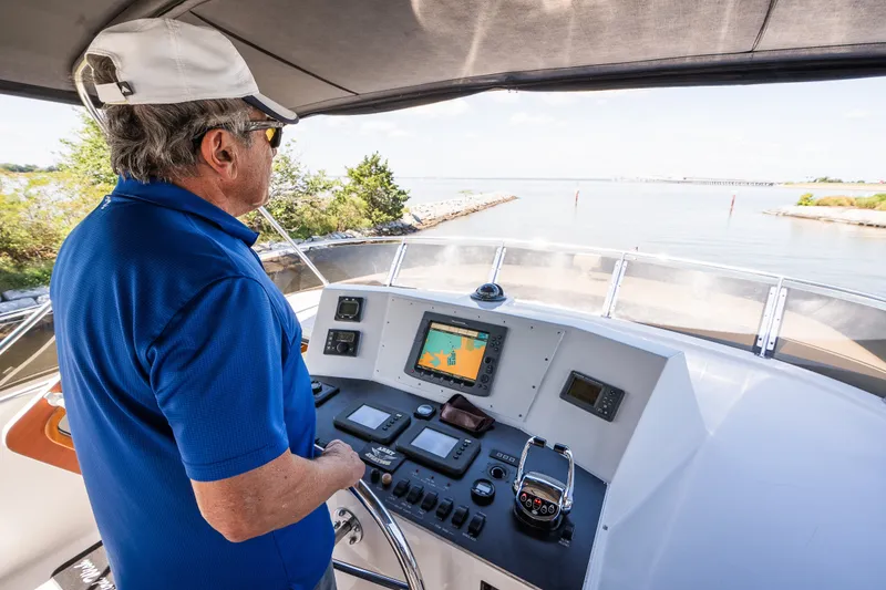 Slide: The Image of Man steering a 2003 Symbol 56 yacht, navigating through calm waters. - 45