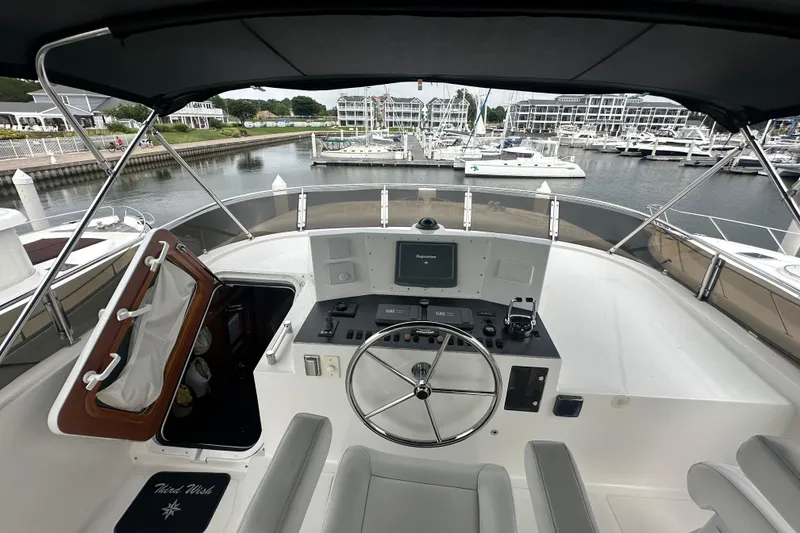 Slide: The Image of Helm of a 2003 Symbol 56 yacht docked at a marina with surrounding boats. - 10
