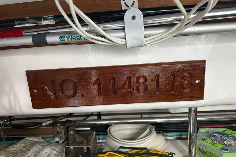 Slide: The Image of Wooden plaque with "NO. 1148118" engraved, surrounded by marine equipment. - 72