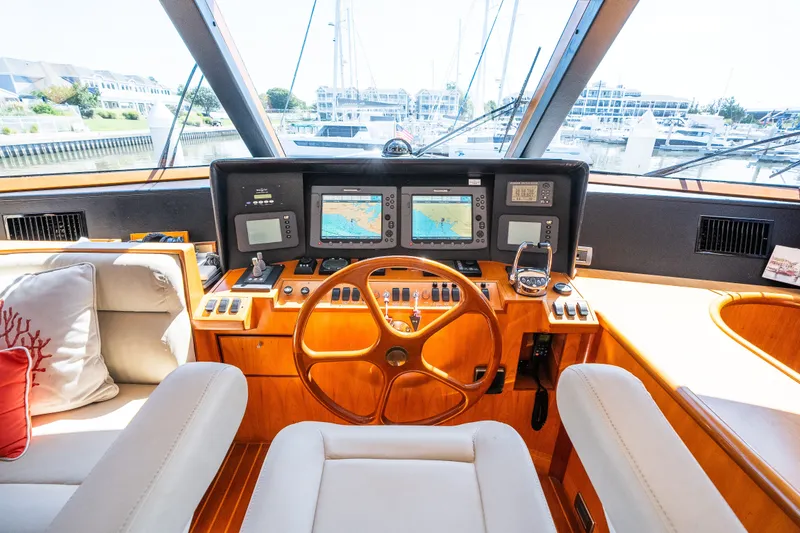 Slide: The Image of Luxurious yacht cockpit with wooden steering wheel, navigation screens, and plush seating, Symbol 56, 2003. - 64