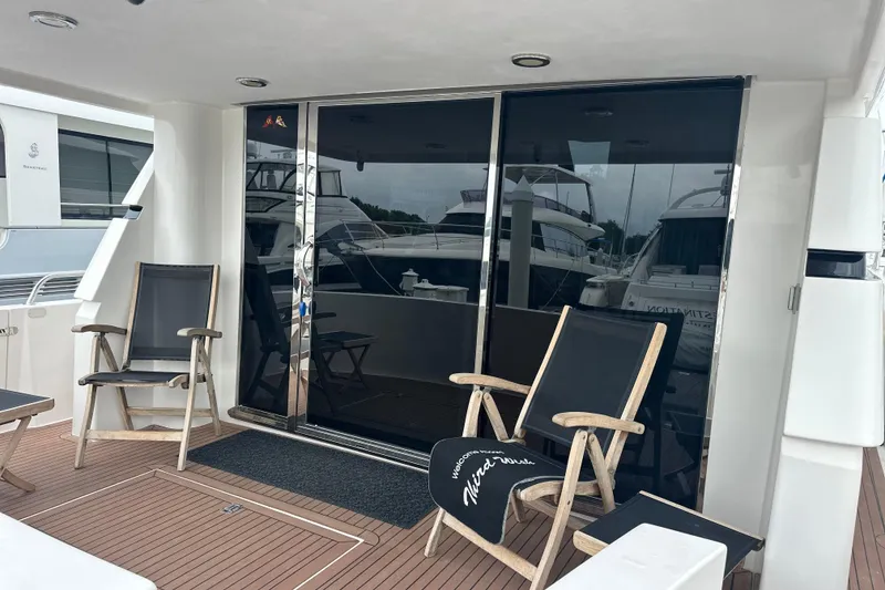 Slide: The Image of Luxury yacht deck with chairs, sliding glass doors, and wooden flooring, Symbol 56, 2003 model. - 6