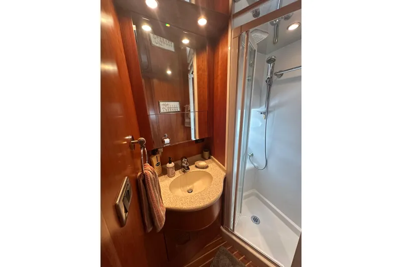 Slide: The Image of Compact yacht bathroom with wooden cabinetry, sink, and enclosed shower, Symbol 56, 2003 model. - 58