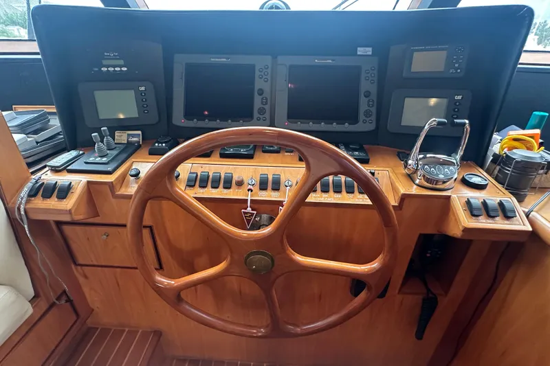 Slide: The Image of Wooden boat helm with multiple navigation screens and controls, Symbol 56, 2003 model. - 36