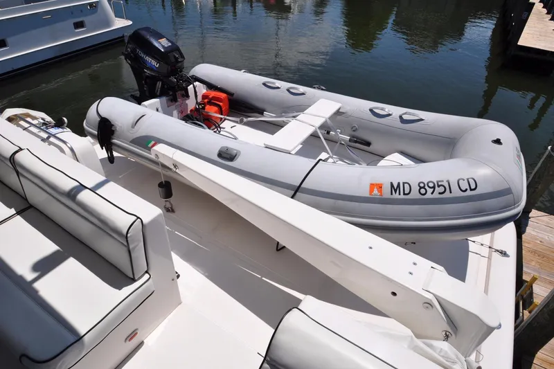Slide: The Image of Inflatable boat with Tohatsu motor on Symbol 56 yacht, docked in marina, 2003 model. - 6