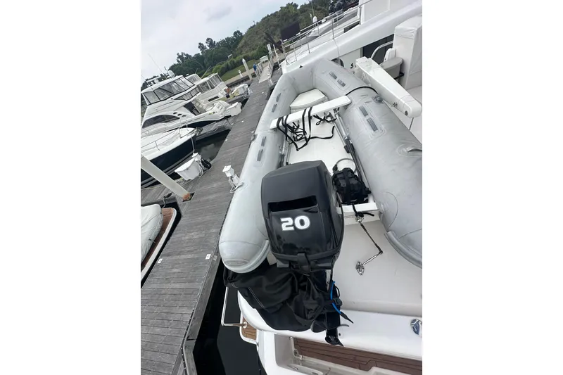 Slide: The Image of Inflatable boat with 20HP motor on a yacht, docked at a marina. - 21