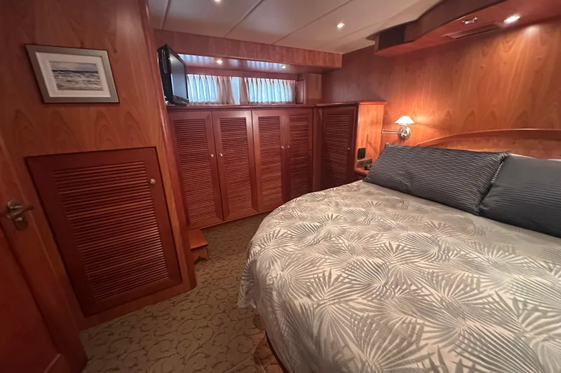 Slide: The Image of Luxurious wooden cabin interior with cozy bed, patterned bedding, and ambient lighting on a Symbol 56 yacht. - 44