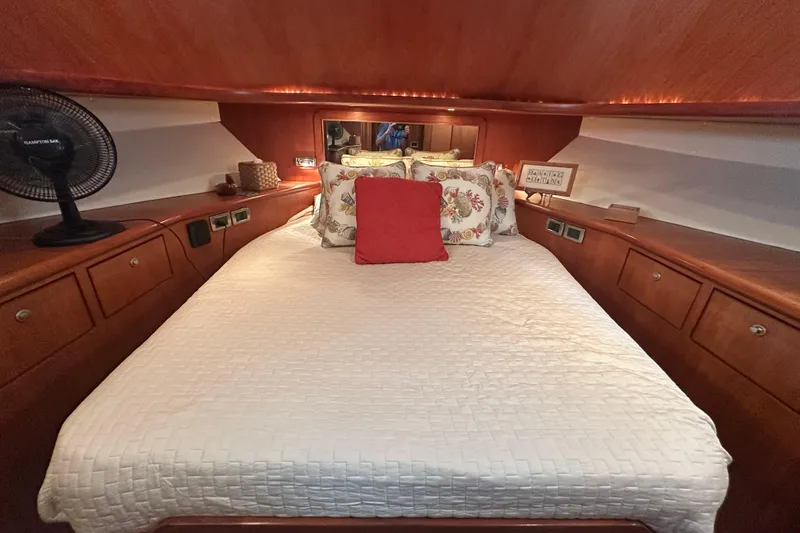Slide: The Image of Luxurious bedroom interior on a 2003 Symbol 56 yacht, featuring elegant wood cabinetry. - 54