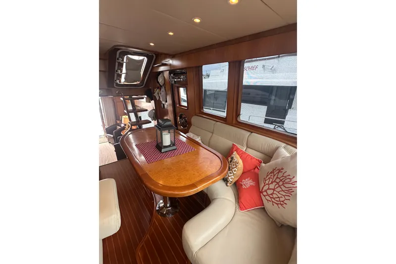 Slide: The Image of Luxurious yacht interior with elegant wood table, plush seating, and decorative pillows, Symbol 56, 2003. - 31