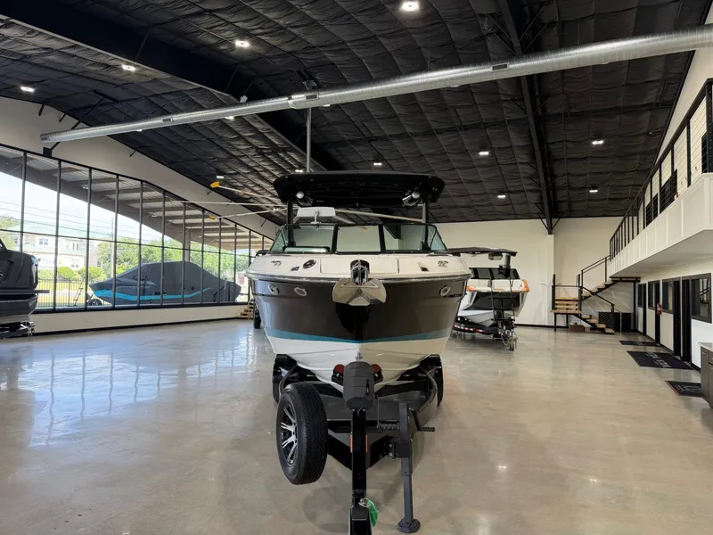 Slide: The Image of A 2024 Sea Ray SLX 260 Surf is on a trailer in a modern showroom. - 8