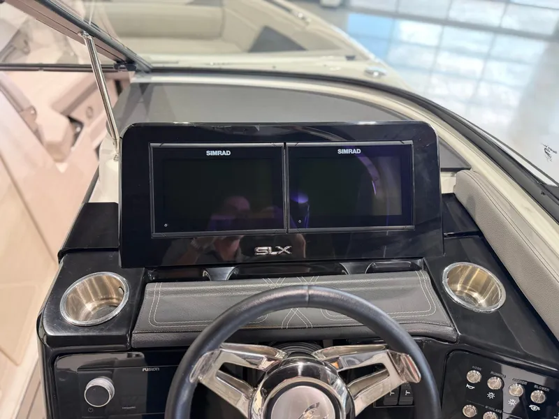 Slide: The Image of The image shows the dashboard of a Sea Ray SLX 260 Surf boat with two Simrad screens. - 23