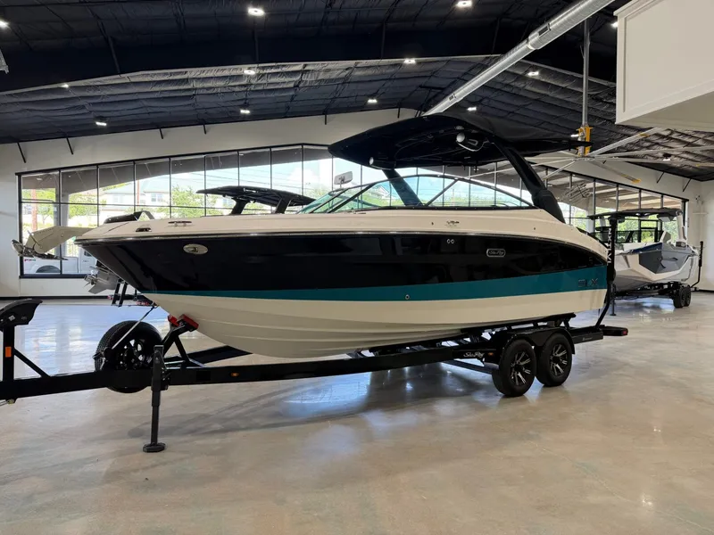 Slide: The Image of A 2024 Sea Ray SLX 260 Surf boat on a trailer in a showroom. - 7