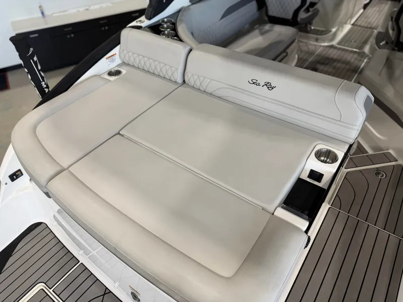 Slide: The Image of The image shows the stern of a 2024 Sea Ray SLX 260 Surf boat with cushioned seating. - 13