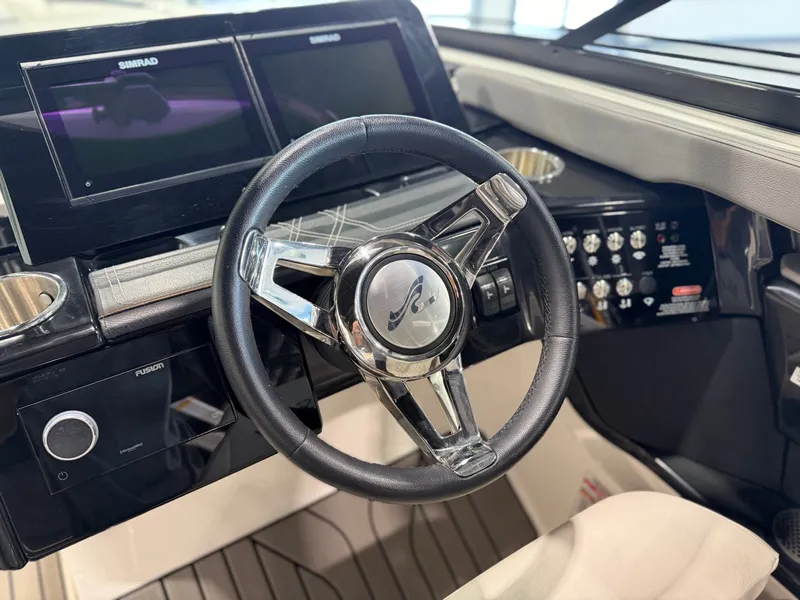 Slide: The Image of The image shows the cockpit of a 2024 Sea Ray SLX 260 Surf with a modern steering wheel and instruments. - 24