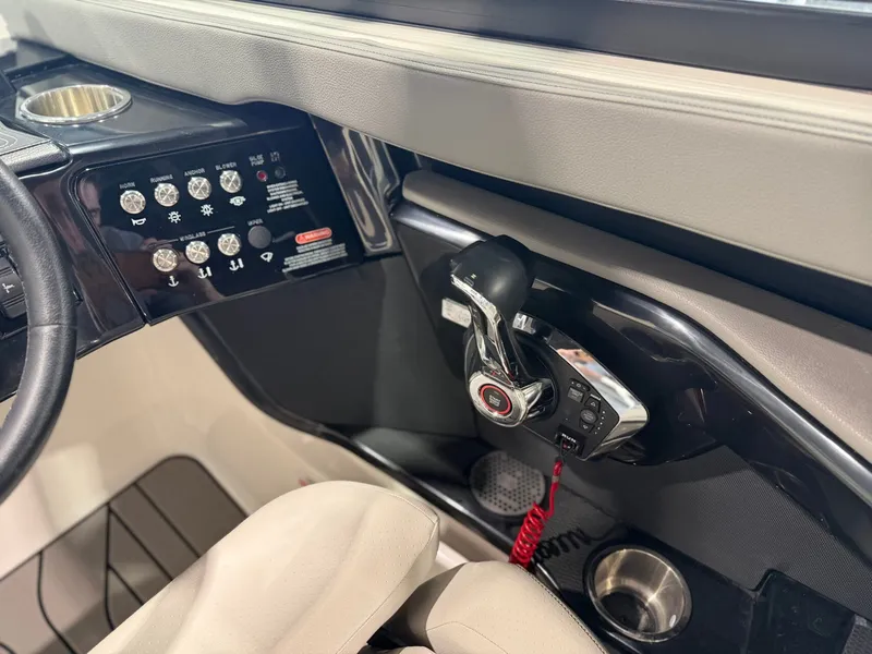 Slide: The Image of The image shows the cockpit of a 2024 Sea Ray SLX 260 Surf with controls and switches. - 25