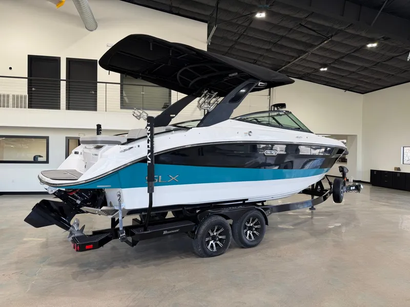 Slide: The Image of A 2024 Sea Ray SLX 260 Surf boat on a trailer in a showroom. - 3