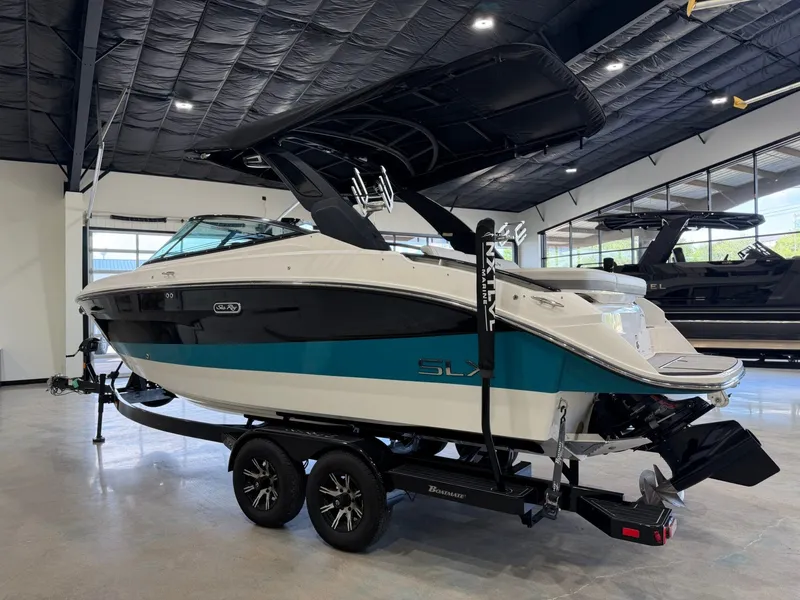 Slide: The Image of A 2024 Sea Ray SLX 260 Surf boat on a trailer in a showroom. - 6