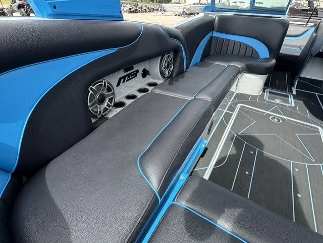 Slide: The Image of The image shows the interior of a 2023 MB SPORTS B52 23 Alpha boat with blue and black seating. - 14