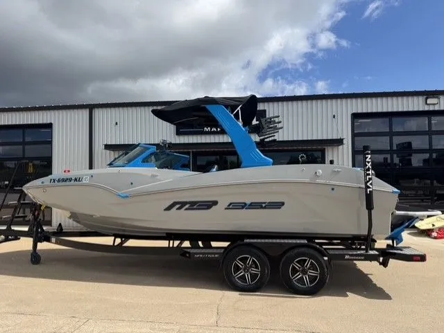 The Image of A gray MB SPORTS B52 23 Alpha boat on a trailer in front of a building. - 1